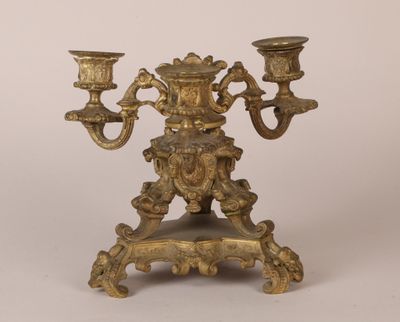 an antique brass candelab with two candles on a stand