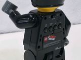 a lego man with a helmet on holding a remote control