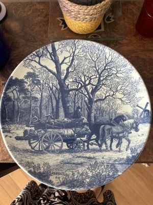a blue and white plate with a horse drawn carriage on it