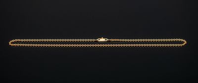 un bracelet à chaîne en or avec un fermoir sur fond noir