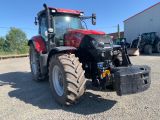 a red tractor that is parked in a parking lot