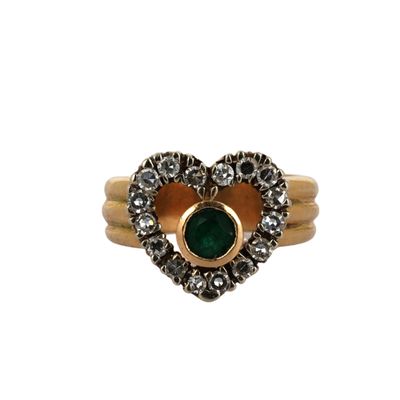 a close up of a gold ring with a green stone in the center