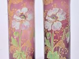 pair of vases with purple and gold designs on them on a white surface