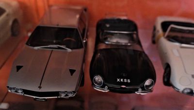 trois voitures exposées dans une vitrine