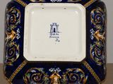 an image of a blue and gold plate with a picture on it