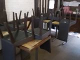 des tables et des chaises dans une pièce avec un mur en briques en arrière-plan