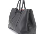 the large black bag is sitting on a white surface