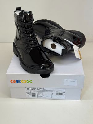 a pair of black boots on top of a white box
