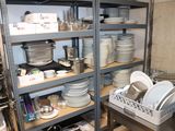 beaucoup d'assiettes et de casseroles sur les étagères de la cuisine