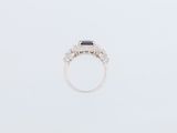a close up of a ring with a black stone surrounded by white diamonds