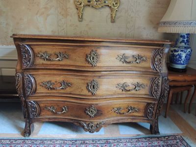 une commode en bois sur un tapis dans une pièce