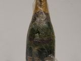 a bottle of champagne wrapped in plastic on a table
