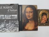 three books on a white table with a picture of a painting and a picture of a woman