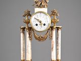 une horloge posée sur un socle en marbre