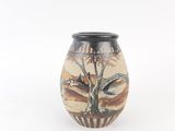 a vase with a painting on it sitting on a table