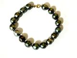 the bracelet is made of black pearls and a gold plated clasp
