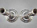 two silver candlesticks sitting on a table