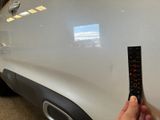a person holding a remote control in front of a car