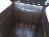 a black metal box with a door open on a tiled floor