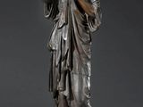 bronze statue of a woman holding a bird on a wooden base
