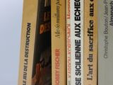 several books are stacked on top of each other on a white surface