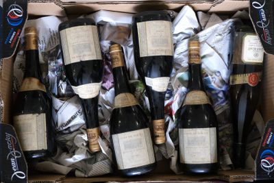plusieurs bouteilles de vin dans un carton posé sur une table
