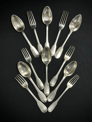 un grand nombre de cuillères et de fourchettes en argent disposées en cercle