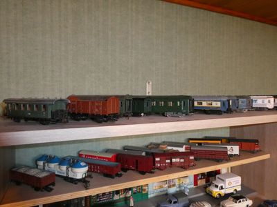 a lot of toy trains on a shelf in a room