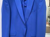 a blue suit hanging on a hanger in a room