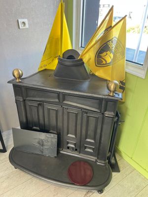 a black stove with a yellow flag on top of it
