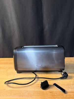 a close up of a toaster on a wooden table with a black background