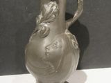 a gray vase that is sitting on a white table