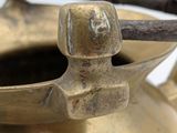 a brass tea pot with a handle on a table