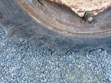a close up of a tire on a gravel road