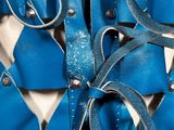 a close up of a blue tie with silver beads on it