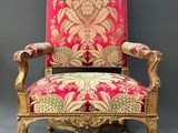une chaise rouge et dorée ornée d'un motif floral