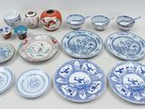 a lot of blue and white plates and bowls on the table