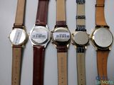four watches are lined up in a row on a white surface