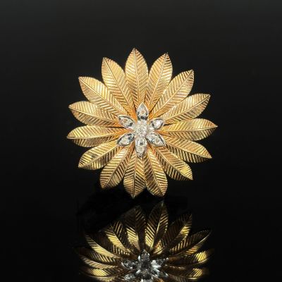 a gold and diamond flower broochle