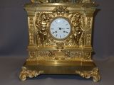 a gold clock with a statue on top of it