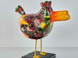 a colorful bird that is standing on a black base