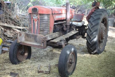 a red tractor that is parked in the grass