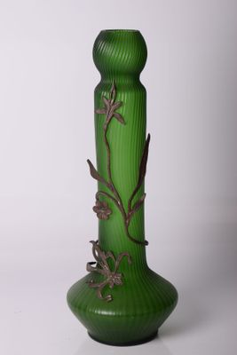 un vase en verre vert orné d'un motif métallique