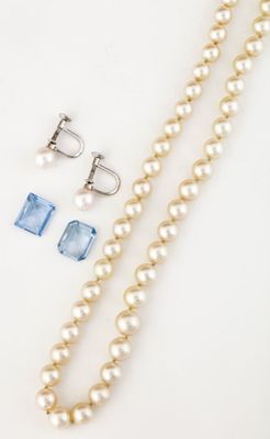 un gros plan sur un collier de perles et une paire de boucles d'oreilles