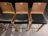 four wooden chairs sitting next to each other on a tiled floor