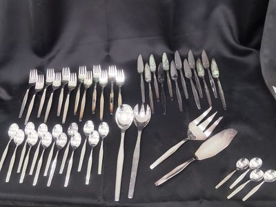 a lot of silverware on a black cloth