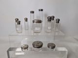 a display of glass jars with silver lids on a clear shelf