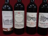 trois bouteilles de vin rouge sont alignées sur un fond rouge