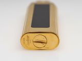 an image of a close up of a gold lighter on a white surface