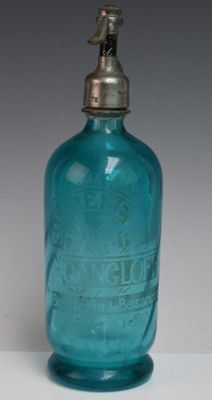 une bouteille en verre bleue avec un bouchon argenté, posée sur une surface blanche